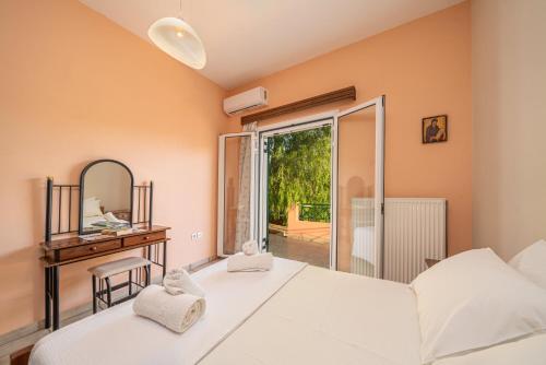 a bedroom with a bed and a mirror and a window at cefalonian hideaway in Razáta
