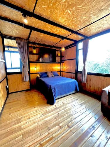 a bedroom with a bed in the middle of a room at Sans Souci - Cabaña in La Unión