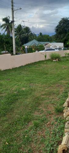 a yard with a fence and a grass field at RiverView Retreat - 2 Bed Escape in Linstead in Linstead