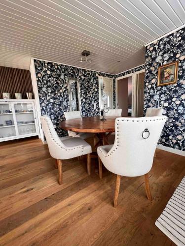 a dining room with a wooden table and white chairs at Skalhamn a village seaside in Lysekil
