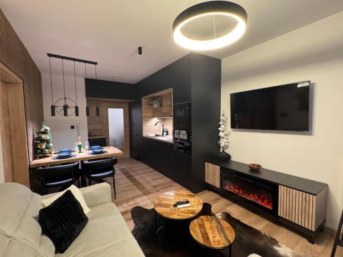 a living room with a couch and a fire place at Luxury Mountain Apartment in Janske Lazne
