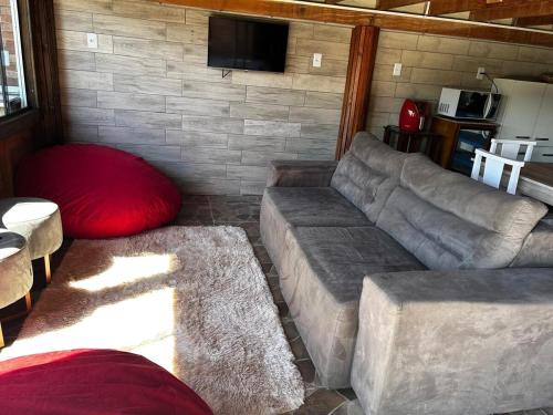 a living room with a couch and a red pillow at Casa com Jacuzzi aconchegante in Imbituba