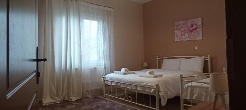 a bedroom with a white bed and a window at Gamila Sunrise in Konitsa