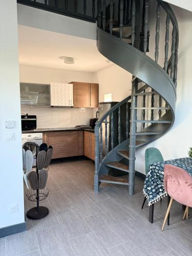 Il comprend une cuisine et un salon avec un escalier en colimaçon. dans l'établissement Duplex 2 chambres proche tram, à LʼÉtang-la-Ville