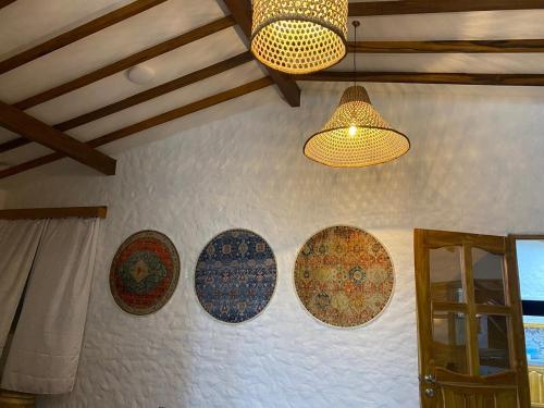 a wall with four plates on it with two lights at Cabaña con piscina para disfrute social y familiar in Chigorodó