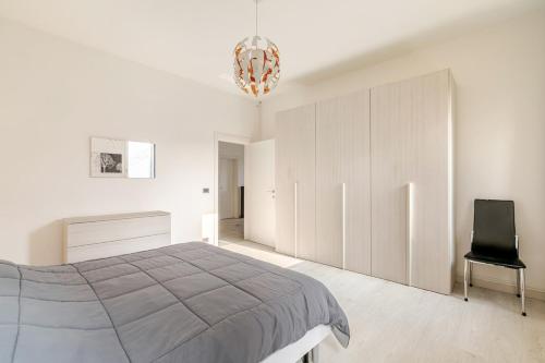 ein weißes Schlafzimmer mit einem Bett und einem Stuhl in der Unterkunft Charme Padovano con Terrazza in Padua