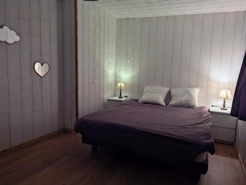 a bedroom with a bed with a heart on the wall at Au Chalet Bourguignon 5 in Salives