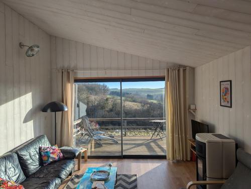 a living room with a couch and a sliding glass door at Au Chalet Bourguignon 5 in Salives