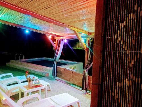 a patio with tables and a swimming pool at night at Casa Vacanze Janas in Ruinas