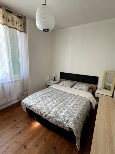 une chambre avec un lit et une grande fenêtre dans l'établissement Appartement paisible, à Villeurbanne
