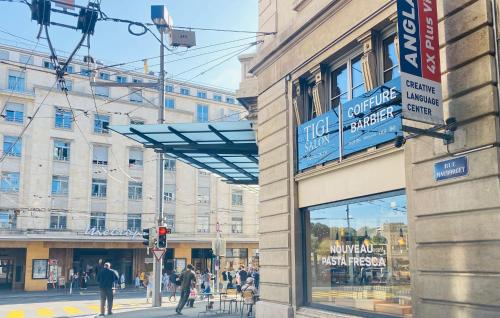 a building on a city street with people walking on the street at City Central Comfort in Lausanne