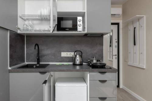 a small kitchen with a sink and a microwave at Затишна квартира поруч з метро Харківська in Kyiv