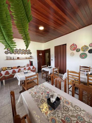 een eetkamer met tafels en stoelen in een kamer bij POUSADA GIRASSOL in Santo Antônio do Pinhal