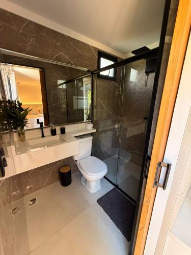 a bathroom with a toilet and a sink and a shower at Pousada Brilho do Sol in Serra Negra