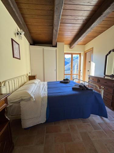 Villa Paterno في Amandola: غرفة نوم بسرير ازرق ونافذة