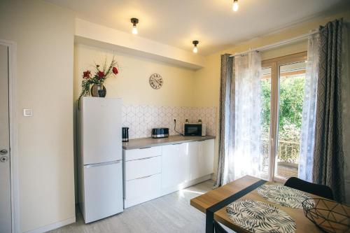 une cuisine avec un réfrigérateur, une table et une fenêtre dans l'établissement Belle maison sur un air de campagne, à Montauban
