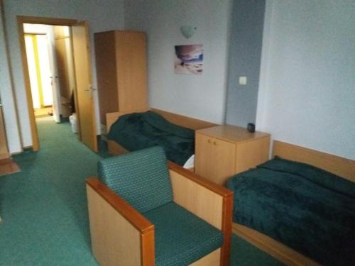 科帕奥尼克Kopaonik Vila Nikola 306 centar的有两张床和一把椅子的酒店房间