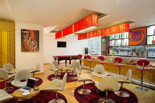 a bar with chairs and a piano in a room at ibis Bengaluru Hosur Road - An Accor Brand in Bengaluru