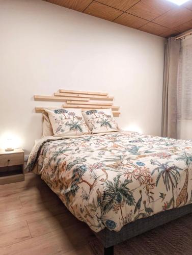- une chambre avec un lit doté d'un couvre-lit tropical dans l'établissement L'Atelier des Rêves, à Saverne
