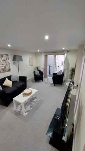 a living room with a couch and a table at Seaside Serenity in Swansea