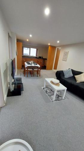 a living room with a couch and a table at Seaside Serenity in Swansea