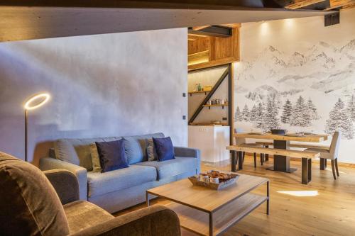 a living room with a blue couch and a table at La Ferme à Roland ski in - ski out - Happy Rentals in Chamonix-Mont-Blanc