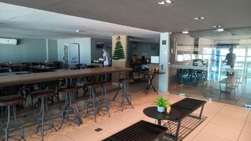 Flat Beira Mar em Manaíra - Aptos de 2 Quartos في جواو بيسوا: بار في مطعم مع الكراسي والطاولات