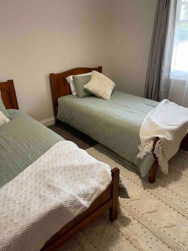 a bedroom with two beds and a window at Schillington Cottage in Mildura