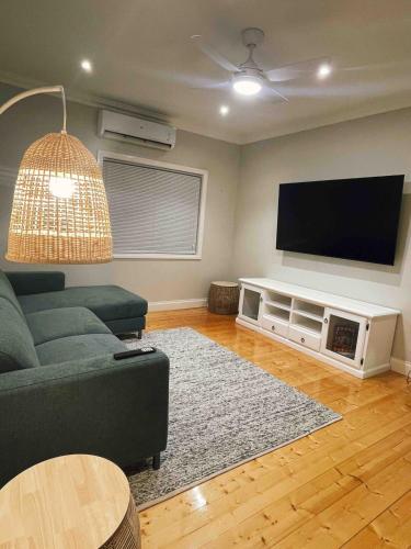 a living room with a couch and a flat screen tv at Schillington Cottage in Mildura