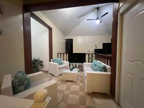 a living room with white couches and a ceiling fan at Casa en río san Juan 4 habitaciones in Río San Juan
