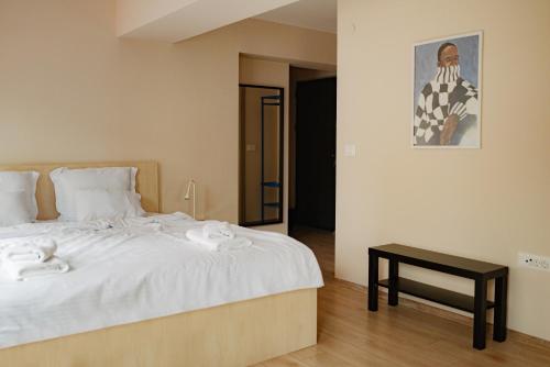 a bedroom with a bed with white sheets and a table at Central Studio Apartments by Parkside Boutique in Skopje
