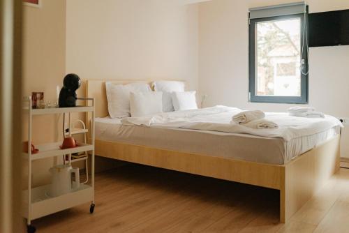 a bedroom with a bed with white sheets and a window at Central Studio Apartments by Parkside Boutique in Skopje