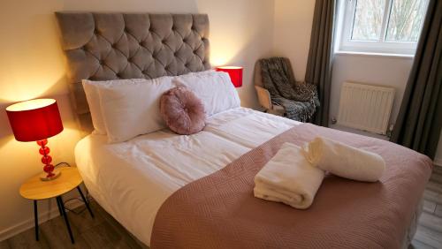 a bedroom with a bed with two donuts on it at A Place to Pause, A Place to Belong, Charming Three Bedroom Rainham Retreat with Parking and WiFi in Swindon