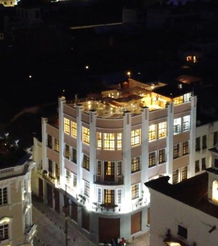 a large white building with lights on it at night at Hotel Sucre in Quito