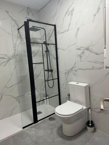 a white bathroom with a toilet and a shower at Alojamiento Baeza - Chicharro A in Baeza