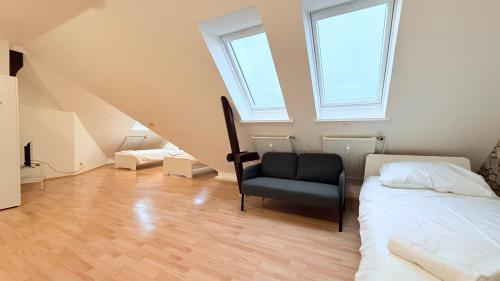 a attic room with a bed and a chair at Zentrale Monteurwohnung Neumünster mit Küche & WLAN in Neumünster