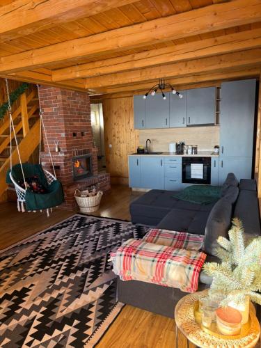 a living room with a couch and a kitchen at Panoramic House in Mărişel