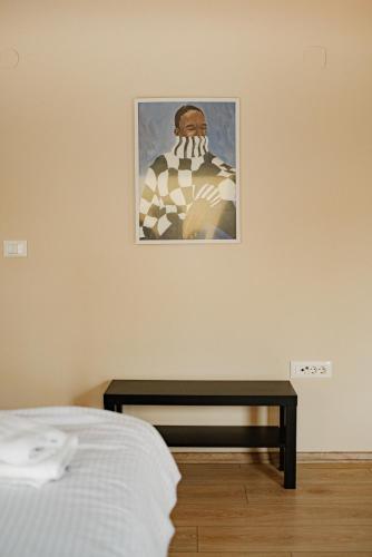 a bed and a table with a picture on the wall at Central Studio Apartments by Parkside Boutique in Skopje
