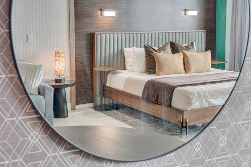 a mirror reflecting a bedroom with a bed and a chair at AVA SUITE 37th FLR STRIP VIEW BALCONY Palms Place in Las Vegas