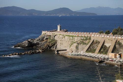 a lighthouse on a cliff next to the ocean at My house in Piombino