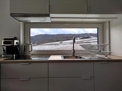 a kitchen with a sink and a large window at Domek Bella in Baligród