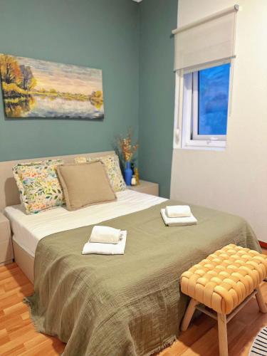 a bedroom with a bed with two towels on it at Downtown A whole house duplex designed for remote work and near metro lapa in Porto