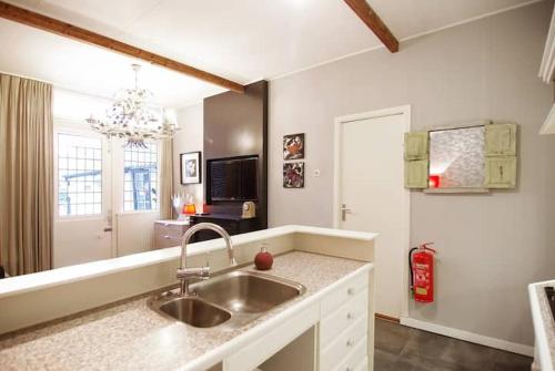 cocina con fregadero y espejo grande en Group Stay, 7 minutes away from Amsterdam!, en Halfweg