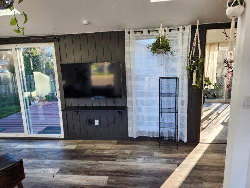 a living room with a tv and a sliding glass door at It's Springtime in the PNW, come on out and enjoy! in Hillsboro