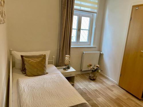 a small bedroom with a bed and a window at Altstadt-Hotel Gosequell in Goslar