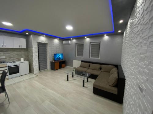 a living room with a couch and a tv at Infinity Apartman Obrenovac, sa parkingom privatnim in Obrenovac