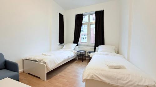 three beds in a room with a window at Zentrale Monteurwohnung Neumünster mit Küche & WLAN in Neumünster