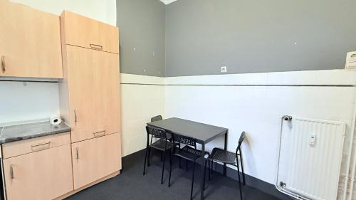 a kitchen with a table and chairs in a room at Zentrale Monteurwohnung Neumünster mit Küche & WLAN in Neumünster