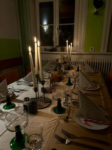 a table with candles and plates and glasses on it at Altstadt-Hotel Gosequell in Goslar