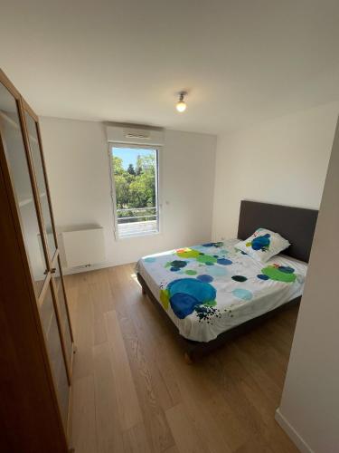 une chambre avec un lit dans une pièce avec une fenêtre dans l'établissement Large apartment with air conditioning, terrace and parking, à Montpellier